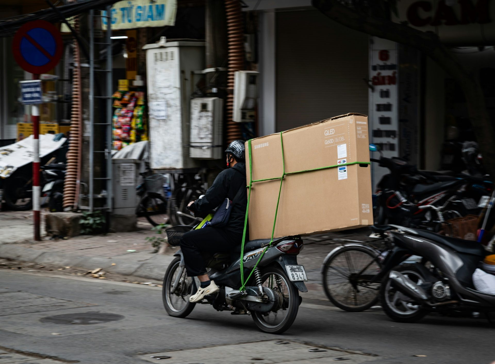 Person riding motorcycle with large box