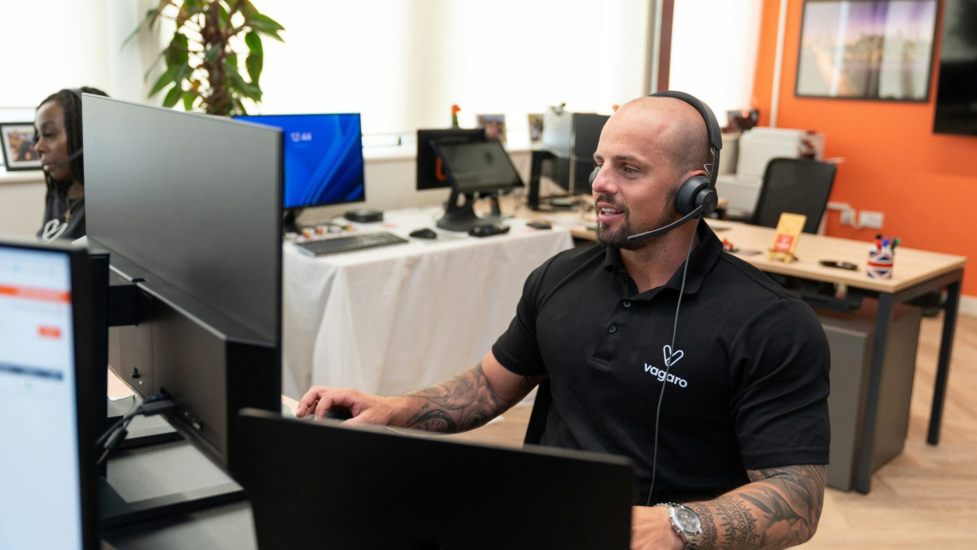 a man wearing a headset sitting in front of a computer
