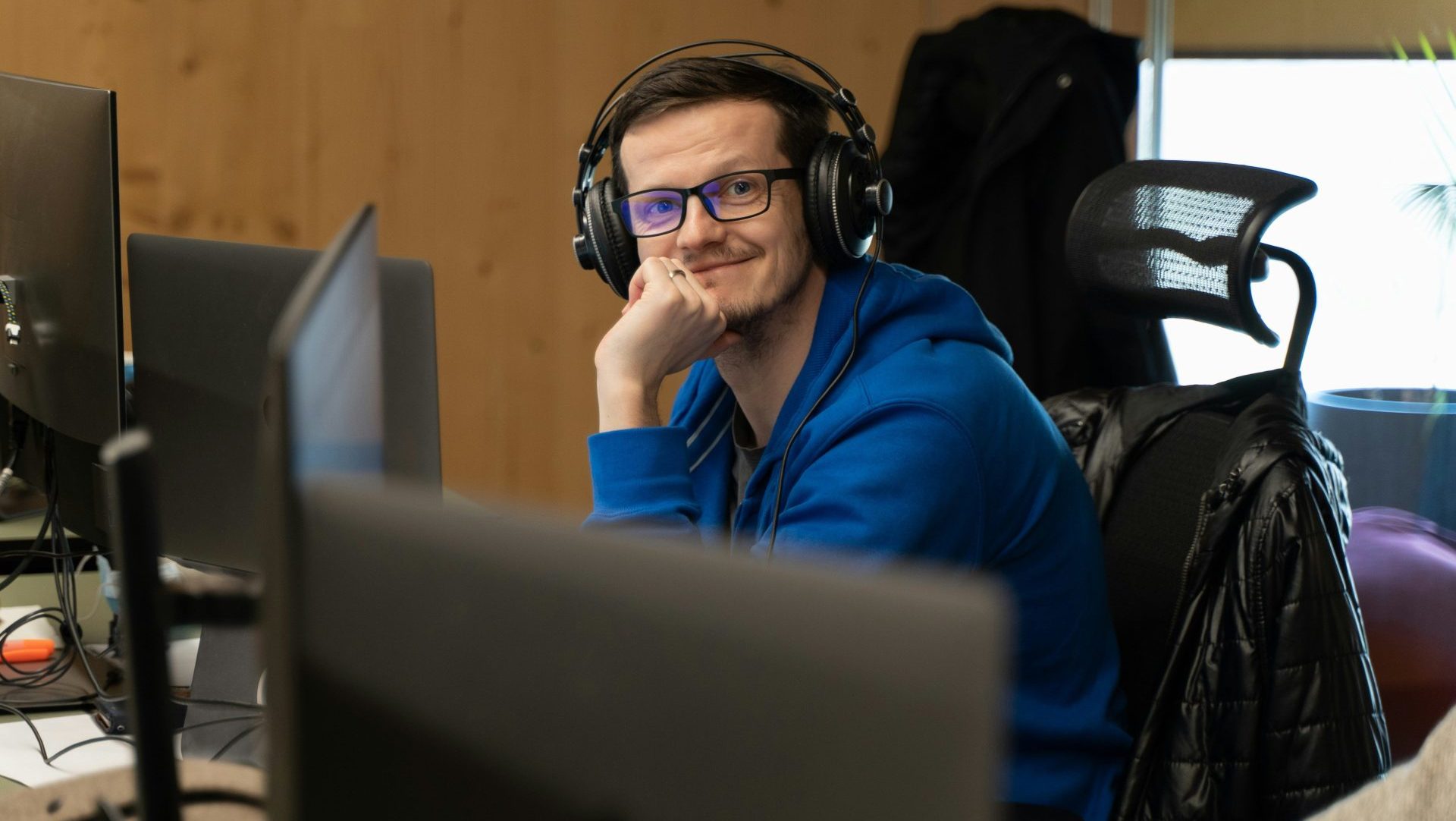 a man wearing headphones sitting in front of a computer