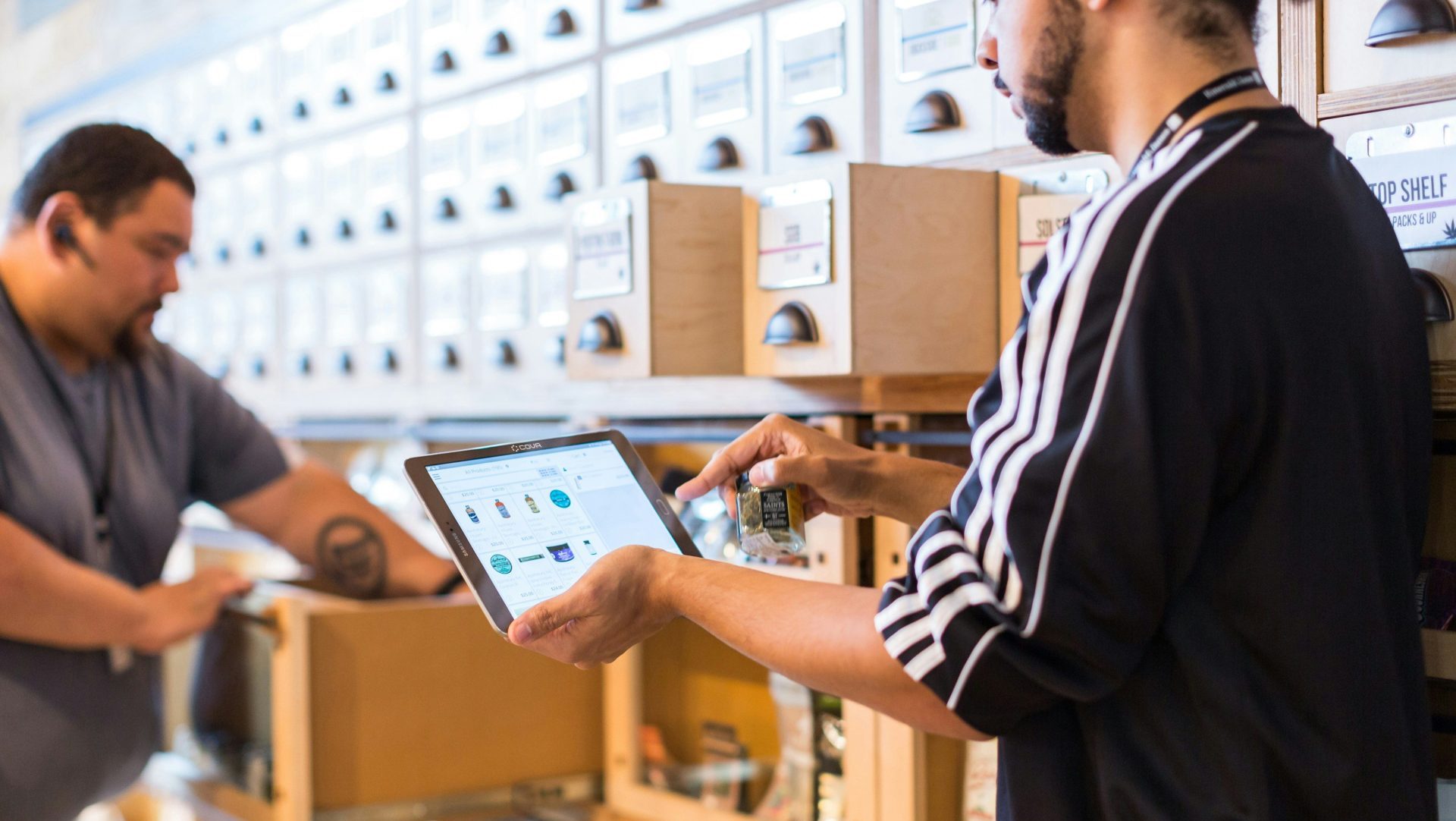two men in a store looking at a tablet