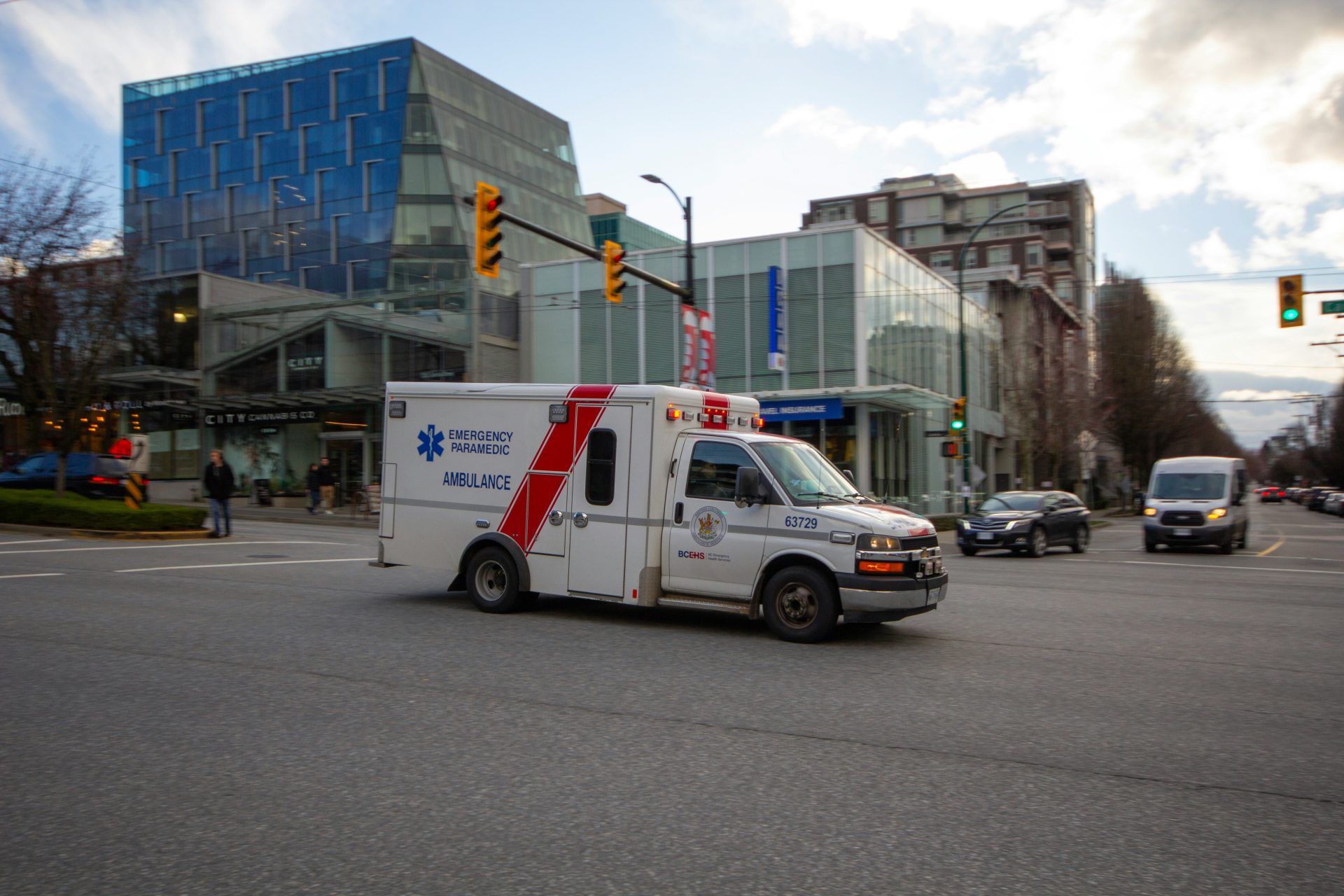 an ambulance driving down a city street next to tall buildings
